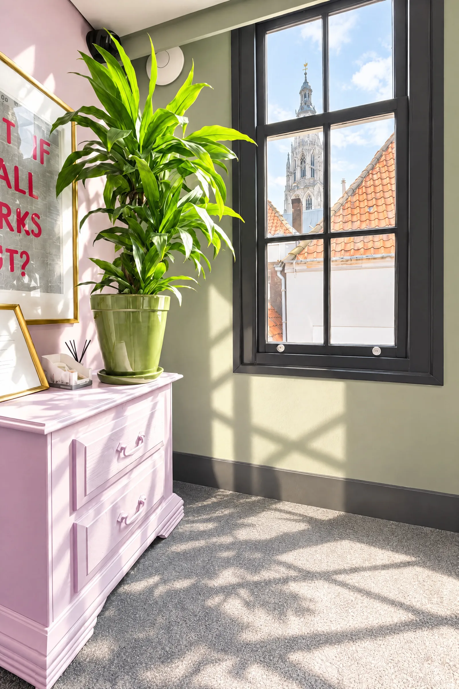 Roze dressoir met plant en uitzicht op de toren van de Grote Kerk
