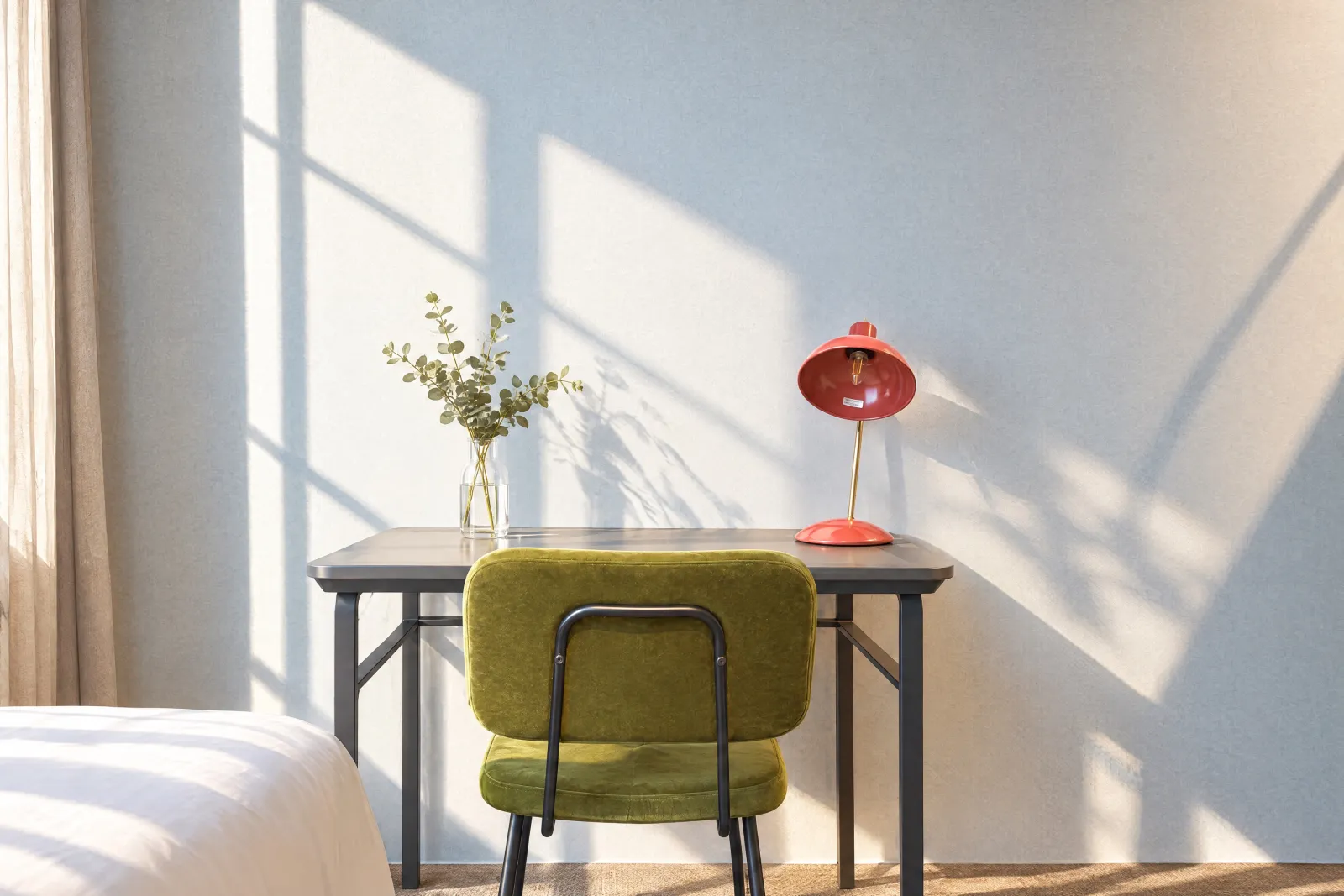 Bureau met groene fluwelen stoel en rode lamp in het zonlicht